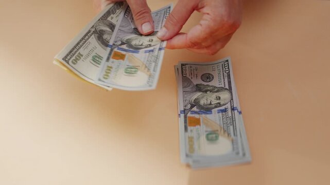 An unrecognizable woman counts American dollar bills close-up.