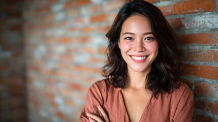 Fototapeta premium A young woman beams with joy, leaning confidently against a textured brick wall, embodying beauty and strength in this vibrant and expressive portrait.