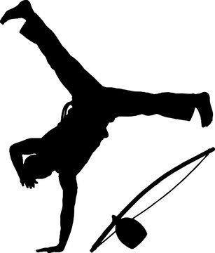 Silhouette of person performing handstand on ground.