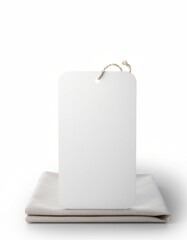 Naklejka premium Blank hanging tag on folded fabric mockup