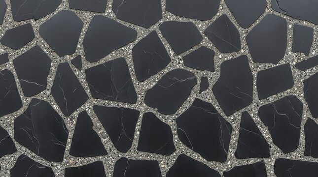 Top view of modern pavement made of irregular black stone slabs with white veins set in grey concrete terrazzo grout, abstract background texture