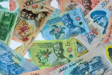 Brunei dollar money banknotes bunch on table. Brunei bills of BND currency close up © Larysa