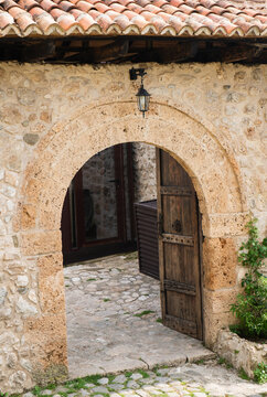 Historic stone archway entrance in Kruja old town, Albania, traditional Mediterranean architecture and rustic courtyard passage.