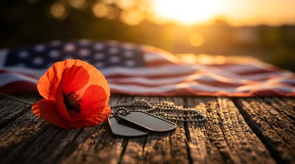 Vibrant red poppy flower rests gracefully beside metallic military dog tags on a weathered wooden surface with a blurred american flag background glowing under the warm light of golden hour sun.