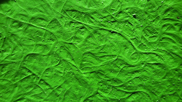 A vibrant, glossy green textured surface covered in a complex, tangled pattern of thick swirling lines and tiny embedded air bubbles.