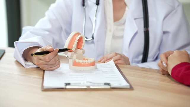 Professional dentist consulting with a patient in a modern dental clinic, explaining teeth restoration, prosthetic options, oral health care, treatment plans, and dental hygiene during a routine check