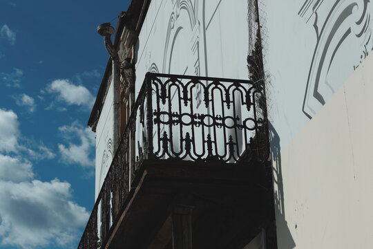 A balcony on a building with a clock tower, perfect for urban or cityscape photography