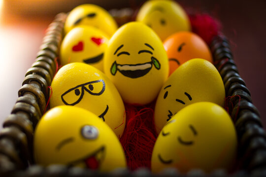 Colorful Easter eggs with expressive emoji faces arranged in a woven basket, featuring various emotions and vibrant colors, perfect for holiday celebrations and decorations