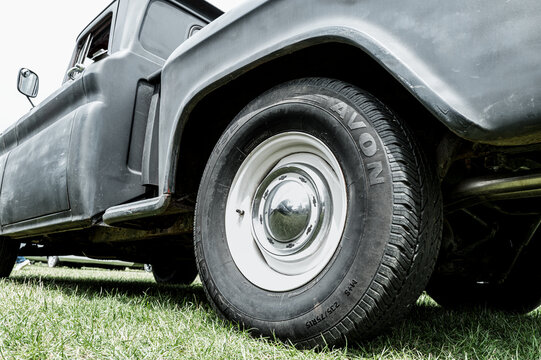 Abstract view of a classic, primer painted American-built Ford pickup truck from the 1960s. Showing detail of the rear wheel and new tyre.