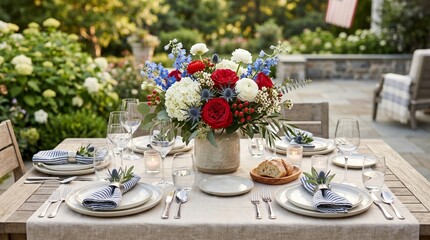 Fototapeta premium Fourth of July celebration outdoors, neutral tableware, flowers in shades of red, white, and blue.