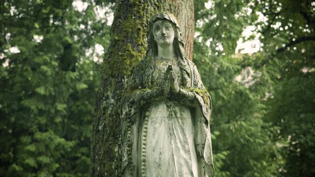 Vilnius, Lithuania &ndash; June 20, 2026: Weathered St. Mary statue in the rain at Bernardine Cemetery