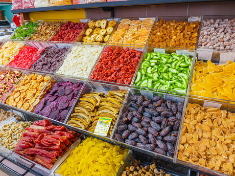 A colorful commercial display of various bright candied dried fruits and sweets at a local market stall, Funchal, Madeira, Portugal.