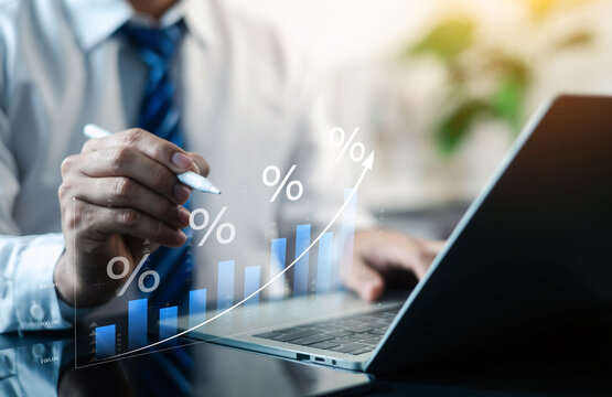 Business professional analyzing financial growth data on laptop with rising chart and percentage indicators, representing investment performance, profit increase, analytics and business success.