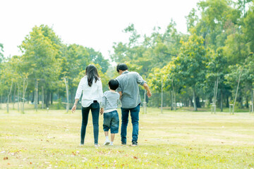 Fototapeta premium Happy Asian family spending time together outside in green nature and park, vacation of parents concept