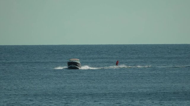 Speedboat wakeboarding ocean watersports action under a clear sky for active lifestyle and summer vacation themes