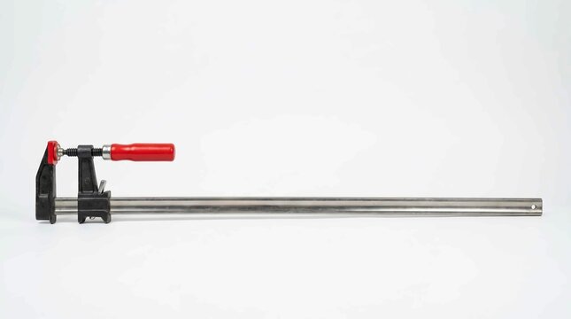 Steel bar clamp with red handle for woodworking projects isolated on a clean white studio background