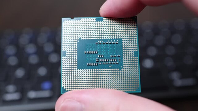 Close up view of bare hands holding CPU microchip module. Concept of global semiconductor shortage, high tech microelectronic component deficit and artificial intelligence development.
