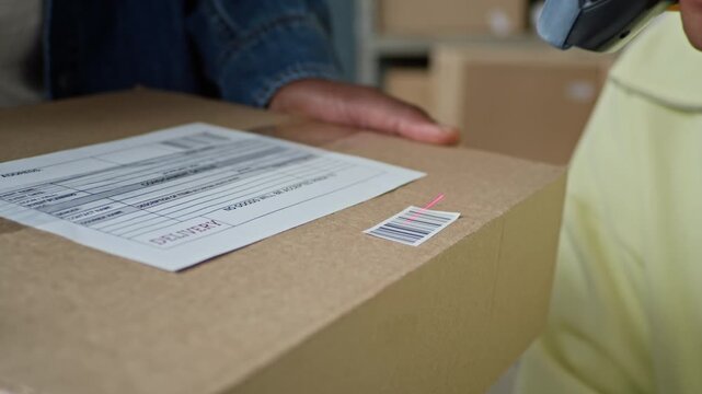 Cropped shot of female warehouse worker scanning barcode on cardboard box held by colleague. Clip perfect for e-commerce logistics and retail delivery services advertisements