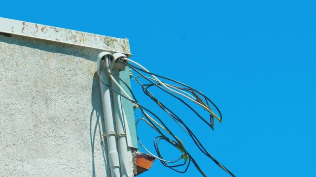 External building service mast with exposed electrical utility wiring