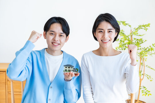 家の模型を持つカップル・夫婦