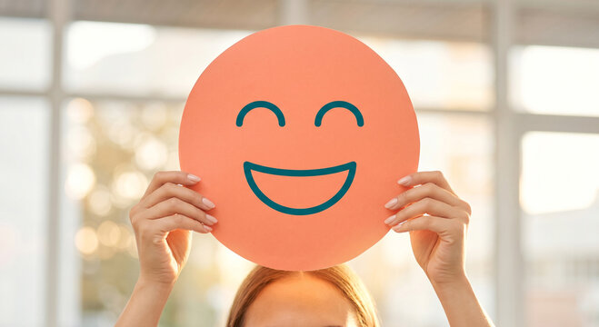 Person Holding Happy Face Balloon Above Head, Joyful Expression, Bright Indoor Setting