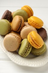 Fototapeta premium Different tasty macarons on white wooden table, closeup