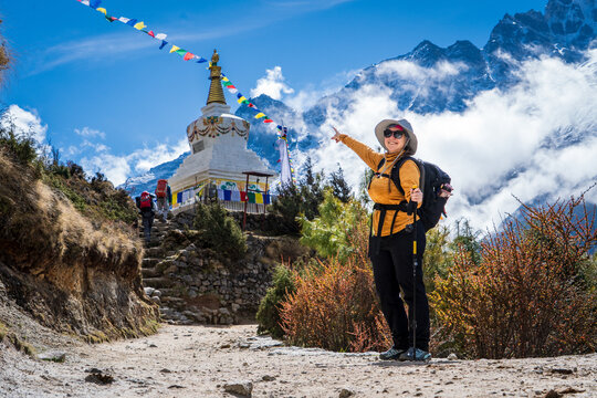 Mujer senderista se&ntilde;alando una estupa budista, en su camino al Everest Base Camp, en Nepal