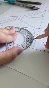 Student or designer drawing a project sketch with pencil and protractor ruler on paper, learning, creativity and technical drawing concept.