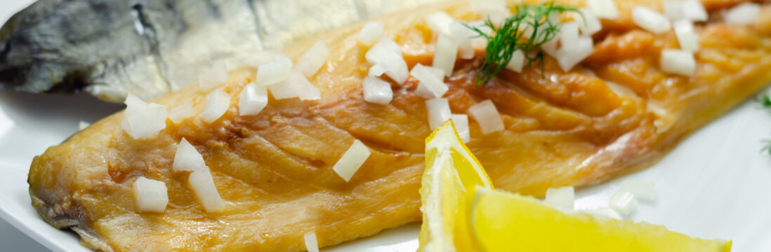 Golden grilled mackerel rests on white plate