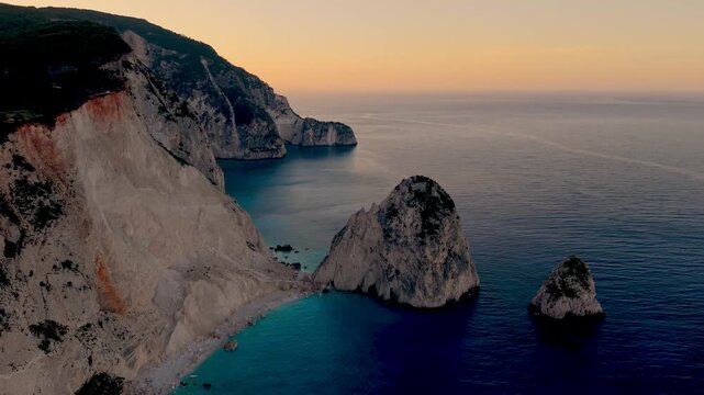 Experience the serene beauty of Myzithres Beach in Keri, Zakynthos as the sun sets, casting vibrant colors across the stunning cliffs and tranquil waters, perfect for a memorable holiday getaway.