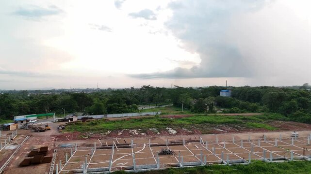 An aerial view showing the site of the initial phase of housing construction, with concrete foundation piles on open land.