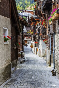 Narrow alley with old houses decorated with flowers in the historic village centre, Grimentz, Val d'Anniviers, Valais Alps, Canton Valais, Switzerland