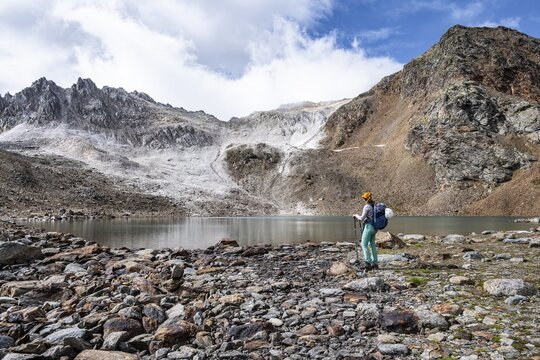 Mountaineer in front of mountain landscape with limestone rocks between granite mountains, mountain lake Hinterer Senner Egetsee and mountain peak of the Moarer Wei&szlig;en, Seven Lakes Hike, Stubai Alps, near Ridnaun, South Tyrol, Italy