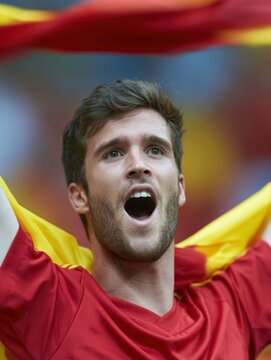 Spanish supporter celebrating passionately with scarf raised high during an international football final