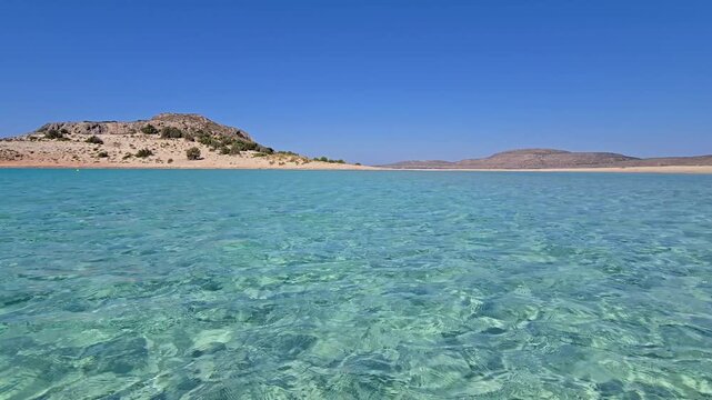 Simos Beach offers stunning turquoise waters and golden sands, ideal for relaxation and sunbathing. Experience the beauty of Elafonisos, Greece in warm sunlight and gentle waves.