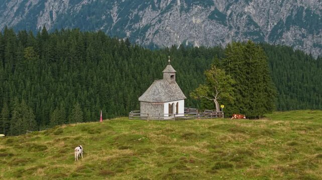 Aerial orbit of Postalmkapelle chapel in mountain pasture at Postalm, Austria