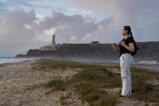 La bonita joven est&aacute; contemplando el sonido de las olas del mar  a un lado de las Salinas de Pampatar y del Faro Punta Ballenas en la Isla de Margarita.