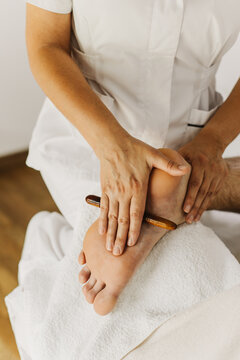 Close up of special foot massage therapy session. Female massage therapist's hands.