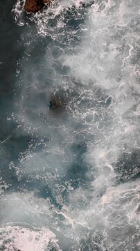 Top view of sea surface with breaking waves and foam, abstract water movement texture