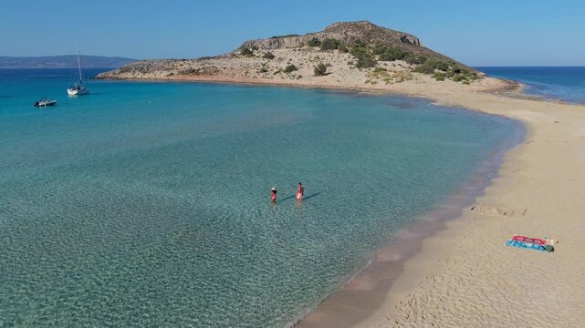 Explore the stunning Simos Beach on Elafonisos, Greece, where turquoise waters meet golden sands. Enjoy sunbathing and swimming in a serene paradise perfect for relaxation.