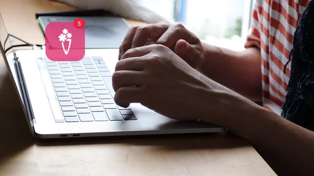 Close up of an Asian man hands typing on a laptop keyboard in casual wear, with a 3D tracked romantic flower bouquet gift notification pop up and red counter.