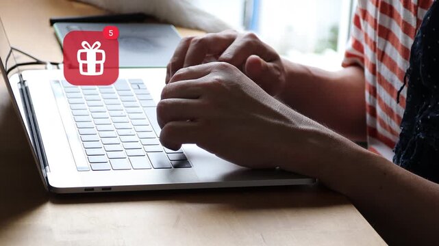 Casual Asian man hands typing on a laptop computer keyboard, featuring a 3D tracked holiday gift box ribbon surprise present notification pop up and red counter.