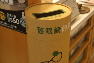Obraz premium Taipei, Taiwan - June 20th 2026 - Kraft paper recycling bin for used eyeglasses inside an optical shop