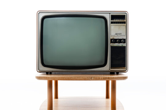 Retro old TV blank screen on wooden table on white background, vintage television in the room.