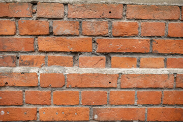Fototapeta premium Close-up of a red brick wall featuring visible mortar joints and a textured surface, highlighting the unique patterns of the bricks