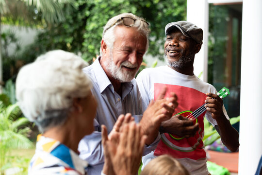 Joyful seniors enjoying music outdoors.