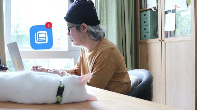 Long white haired mature Asian man using a laptop next to his cat, featuring a 3D tracked digital newspaper press headline notification pop up and red counter.