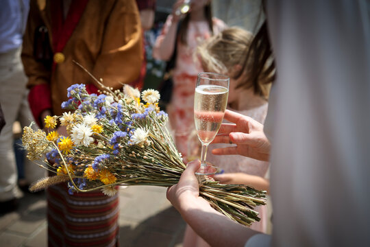 Le bouquet de fleur d'une mari&eacute;e avec un verre de champagne &agrave; la main