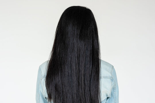 Person with long black hair facing away, wearing a denim jacket.