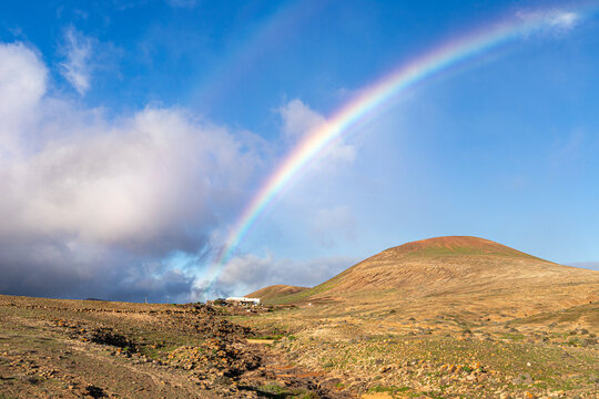 A rainbow over a volcanic landscape near Costa Teguise on the Canary Island of Lanzarote, Spain